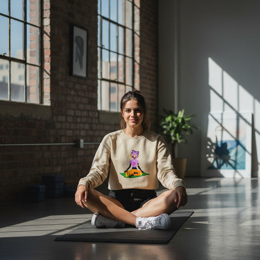 Woman sitting on a yoga mat in a sunlit room with large windows and a plant.